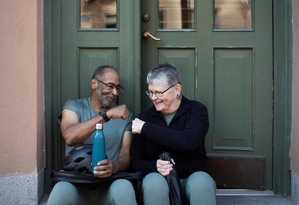 Kvinna och man som sitter framför en port