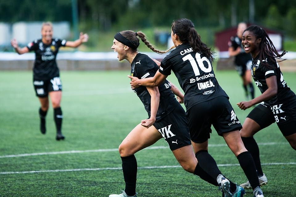 Glada fotbollsspelare som springer på en fotbollsplan.