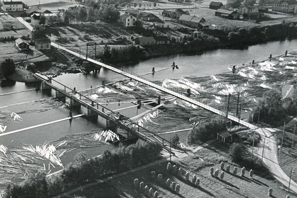 Flottningsdammen och hängbron över Lillån. Nuvarande bro uppfördes uppströms hängbron på 1970-talet. Umeå Flottningsförenings arkiv, Folkrörelsearkivet i Västerbotten. 