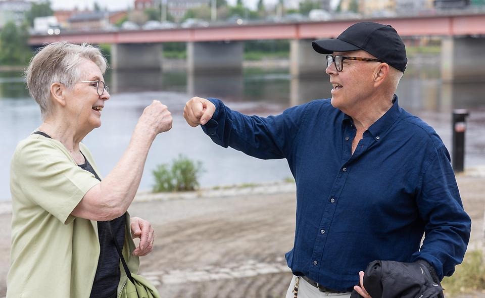 Två glada människor som gör en "high-five" med knuten hand