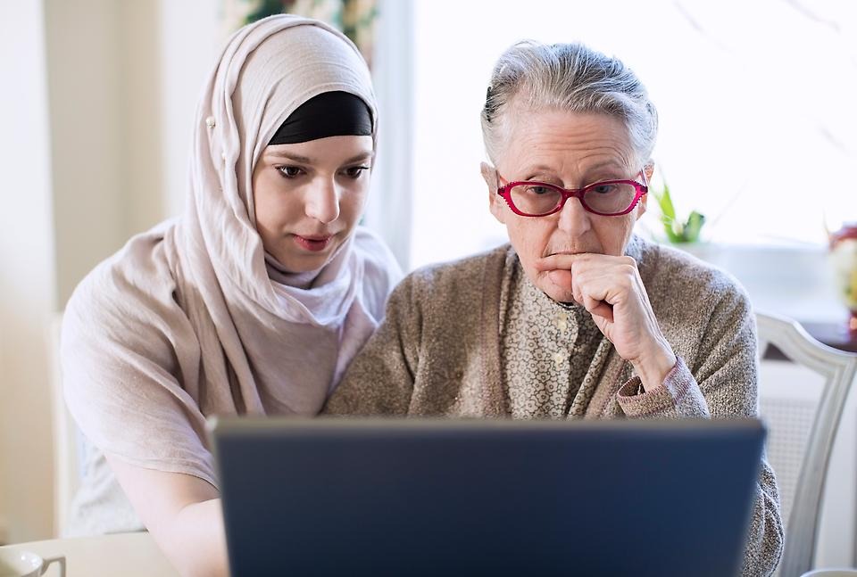 Två kvinnor sitter tillsammans framför en dator