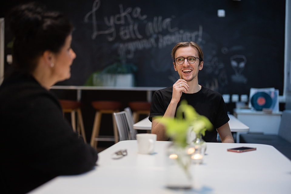 Bilden visar Erik i samtal med en kvinna som arbetar i samma kontorslokaler som honom själv.