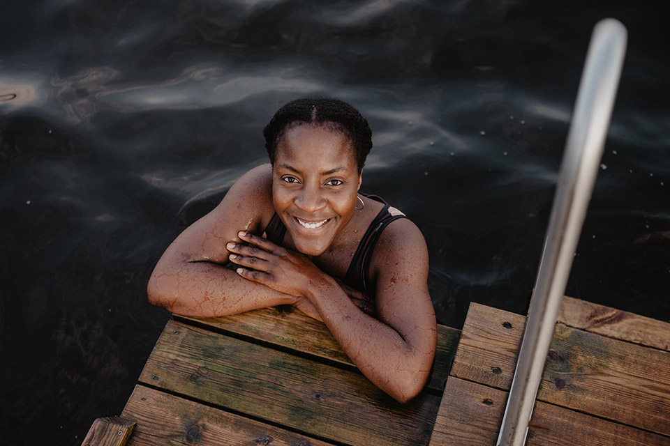 Kvinna badar i sjö intill brygga.