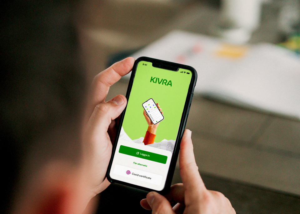 Bild med händer som håller en mobiltelefon där appen Kivra syns