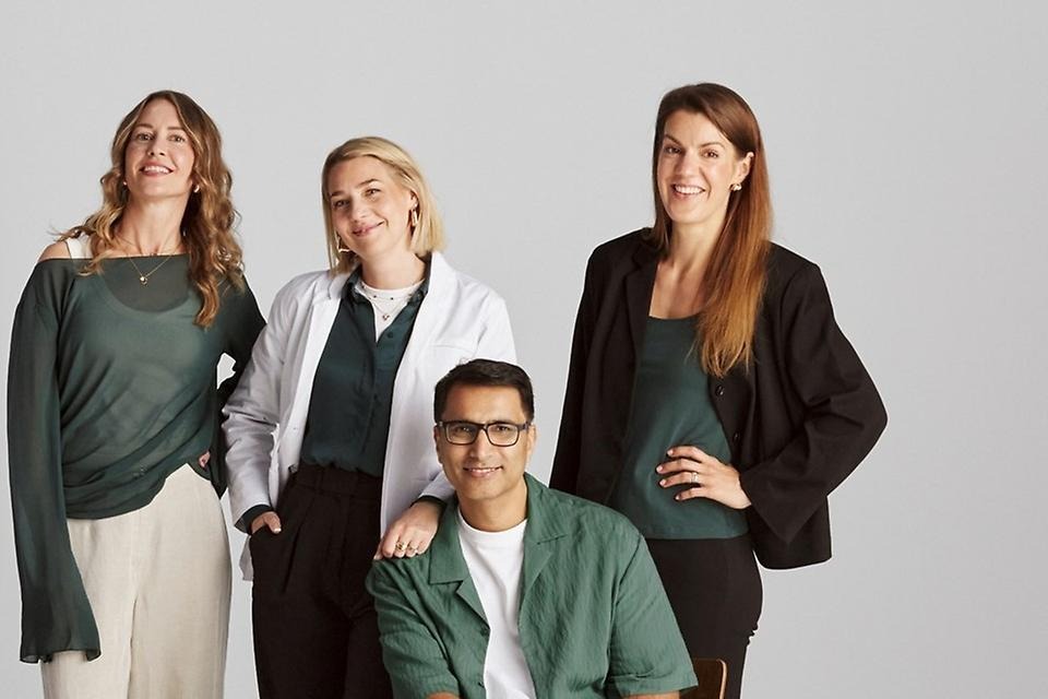 Fyra personer som poserar tillsammans framför kameran