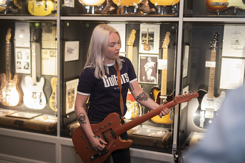 A woman playing electric guitar.