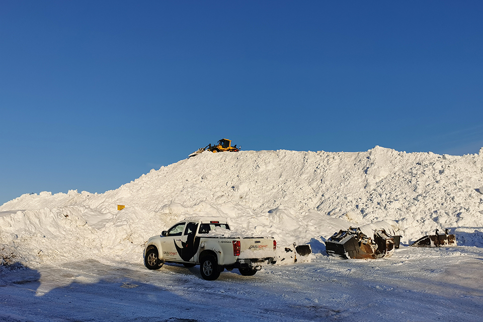 En jättestor hög med snö, en traktor, en liten lastbild