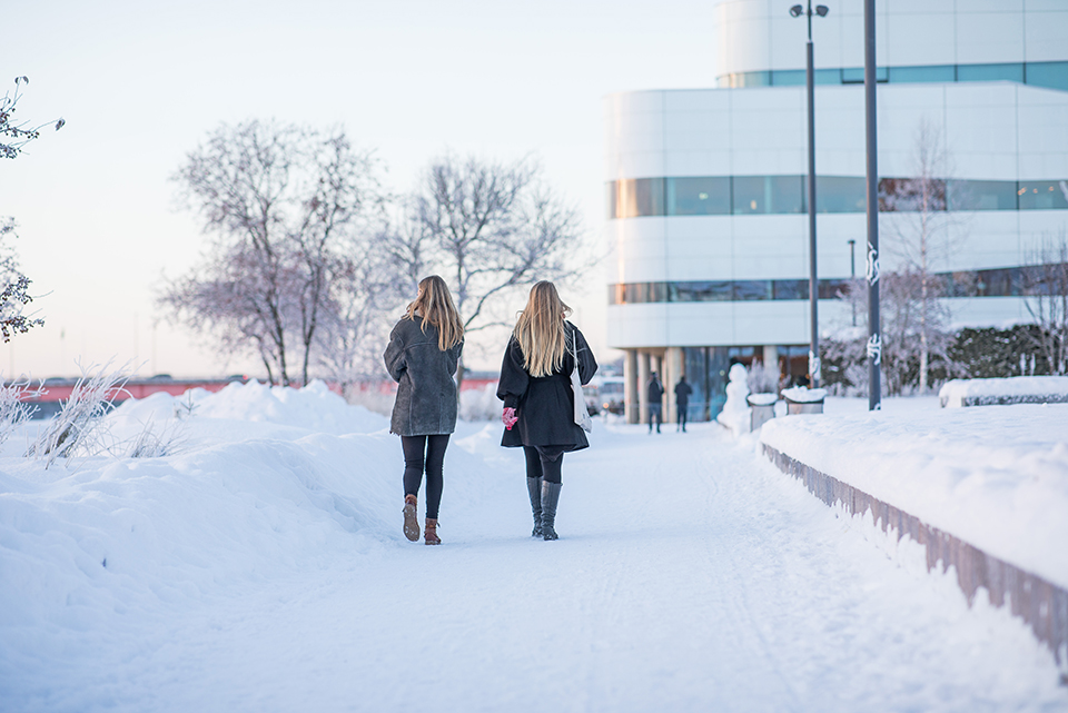 två kvinnor promenerar vid Väven, vinter, snö