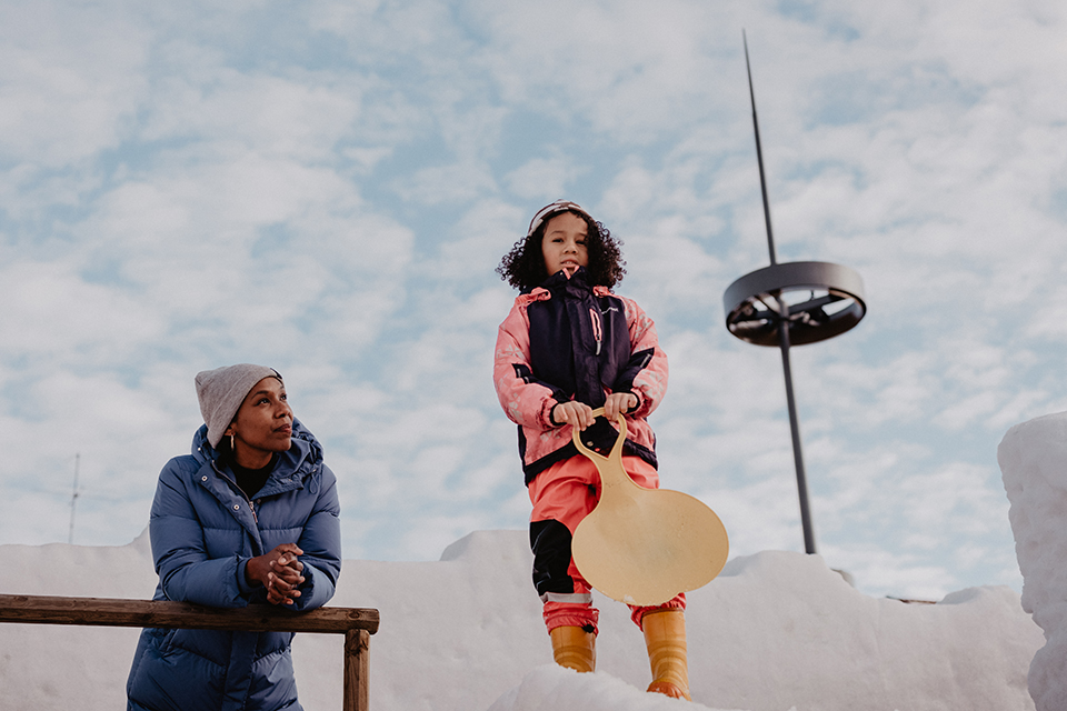 Mamma och dotter leker i snöborg i centrala Umeå