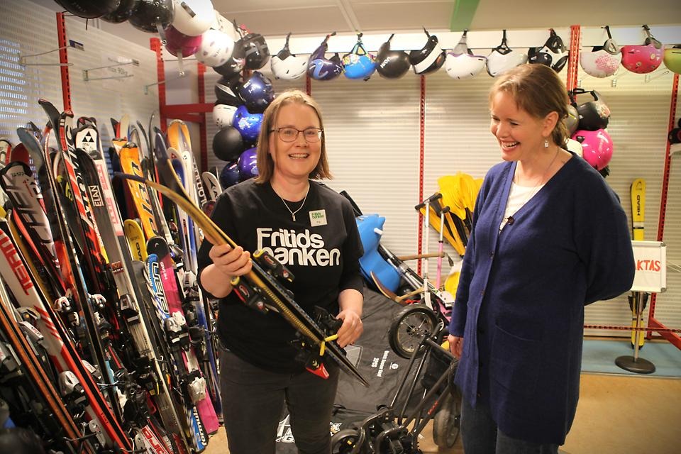 Två kvinnor samtalar om slalomskidor på Fritidsbanken. 
