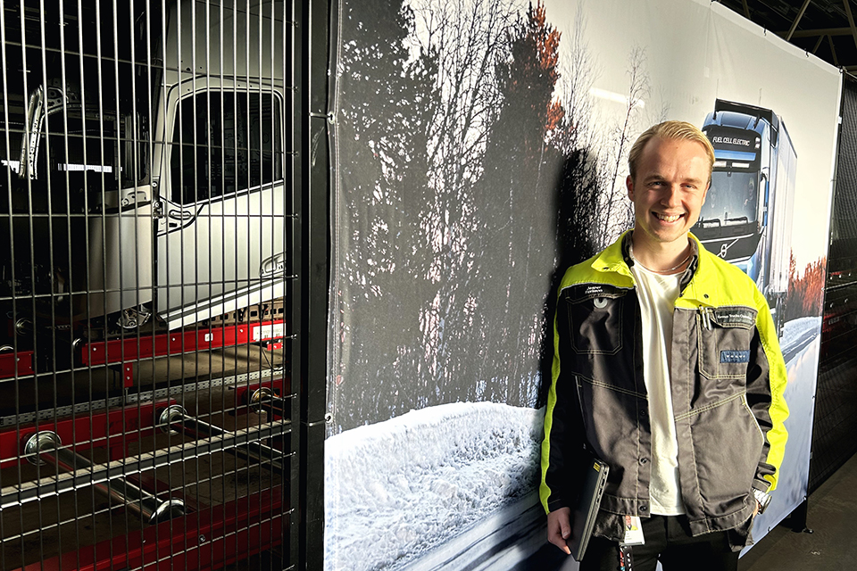 Jesper framför en affisch med Volvolastbil.