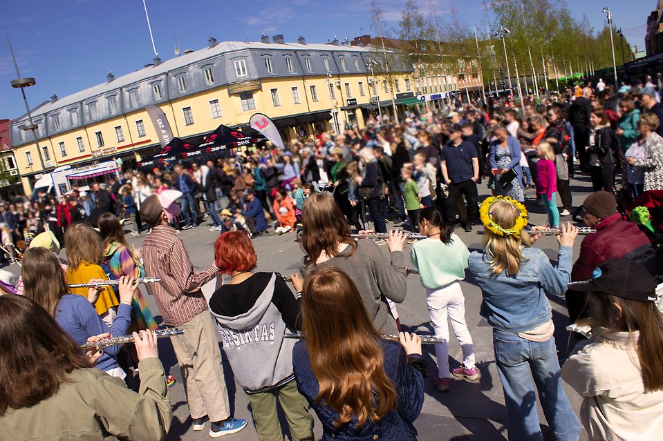 En grupp personer sitter på en gräsmatta.