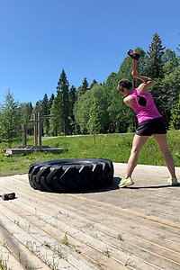 Kvinna som slår med slägga på ett stort däck.