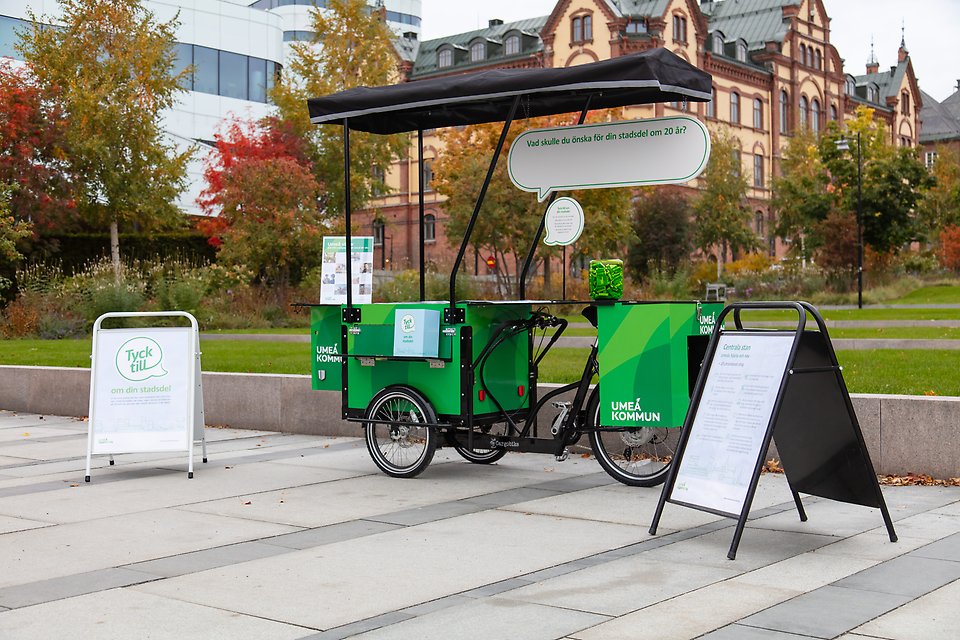 Foto av kommunens dialogcykel uppställd i Rådhusparken med Stora hotellet och Kulturväven i bakgrunden.